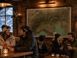 Dog in apres-ski bar with old map of the alps featured on wall.