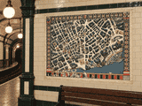 Old London theatre map displayed on a period Underground station wall